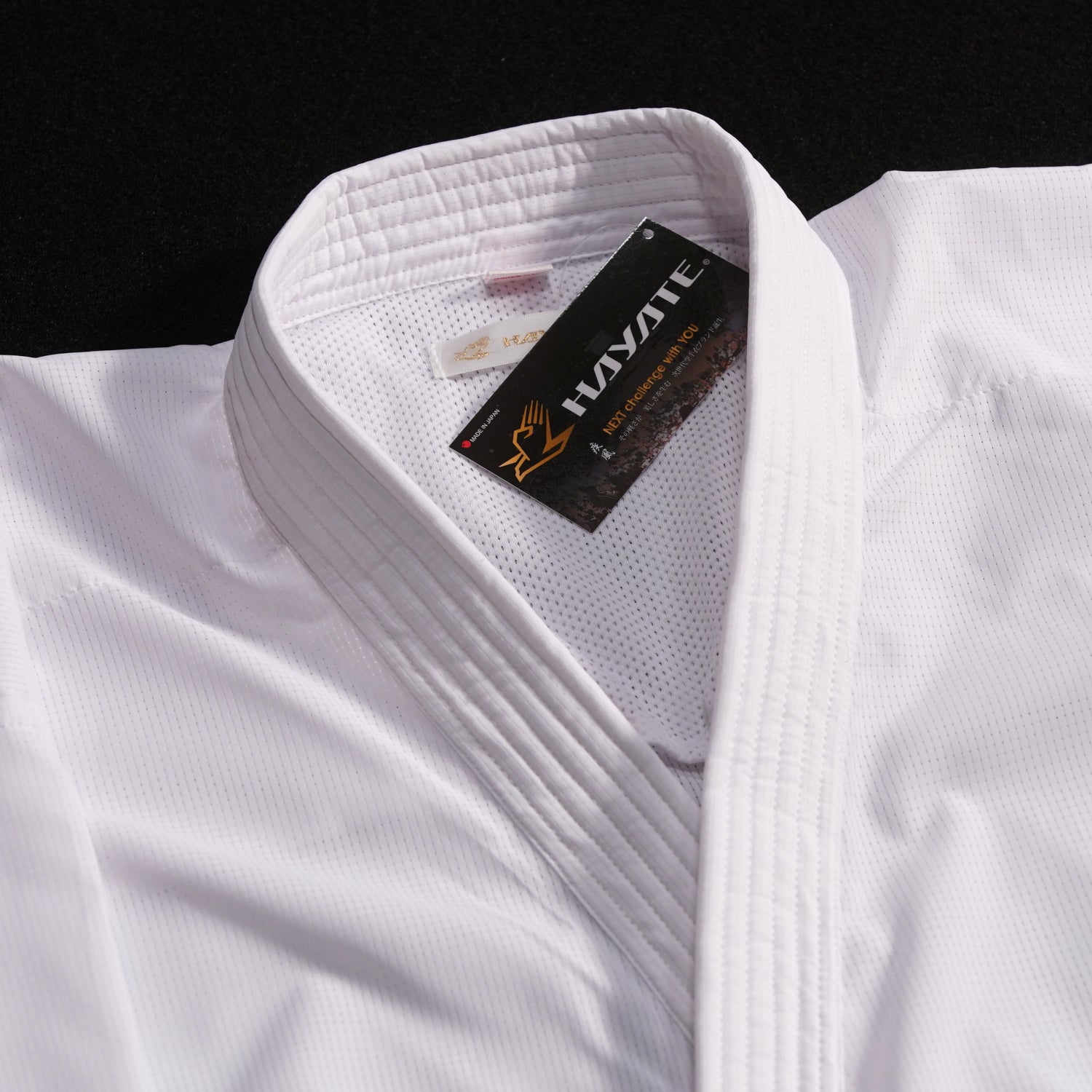 White martial arts uniform with a brand label on a black background