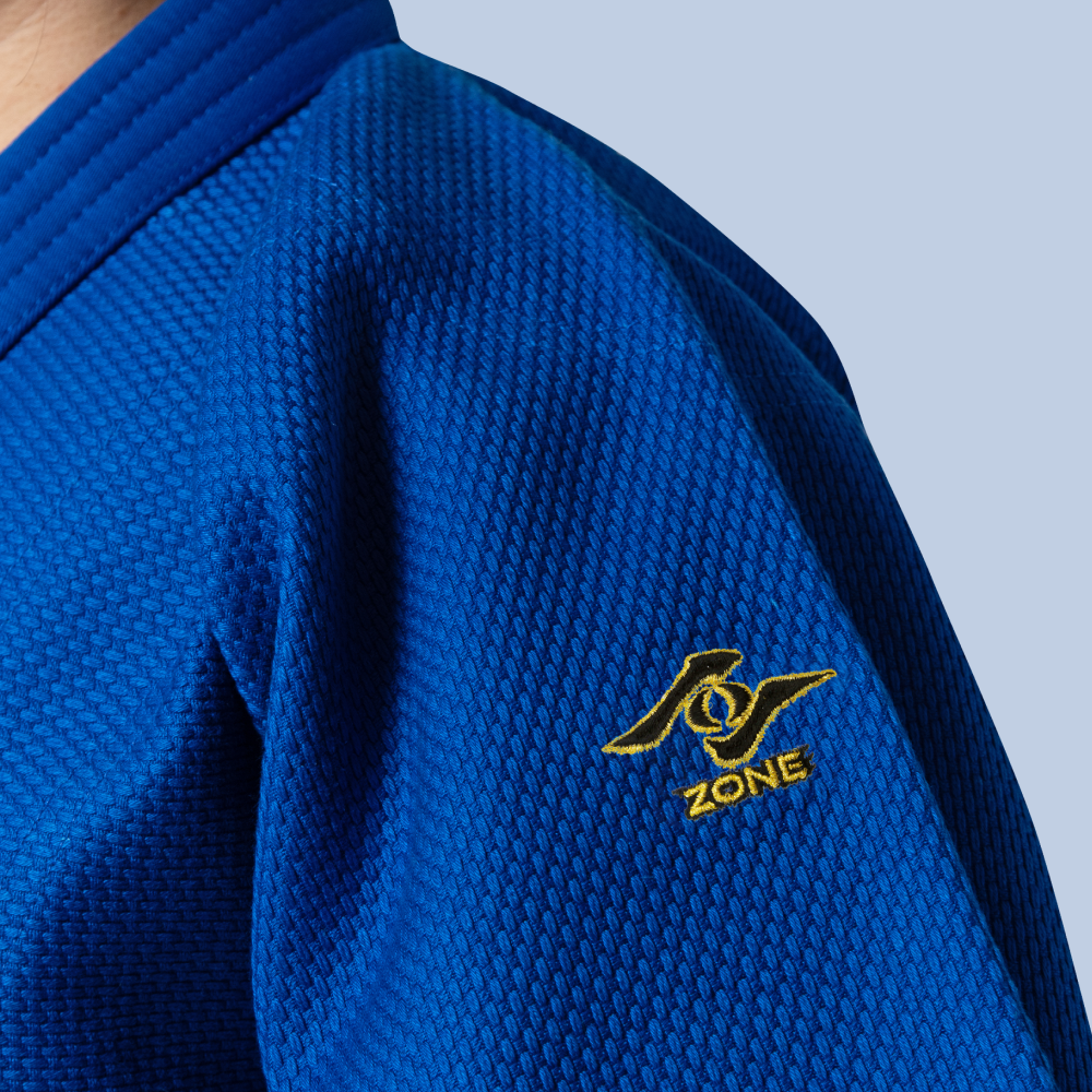 Blue Kiwami judo jacket with the Zone logo on a light blue background