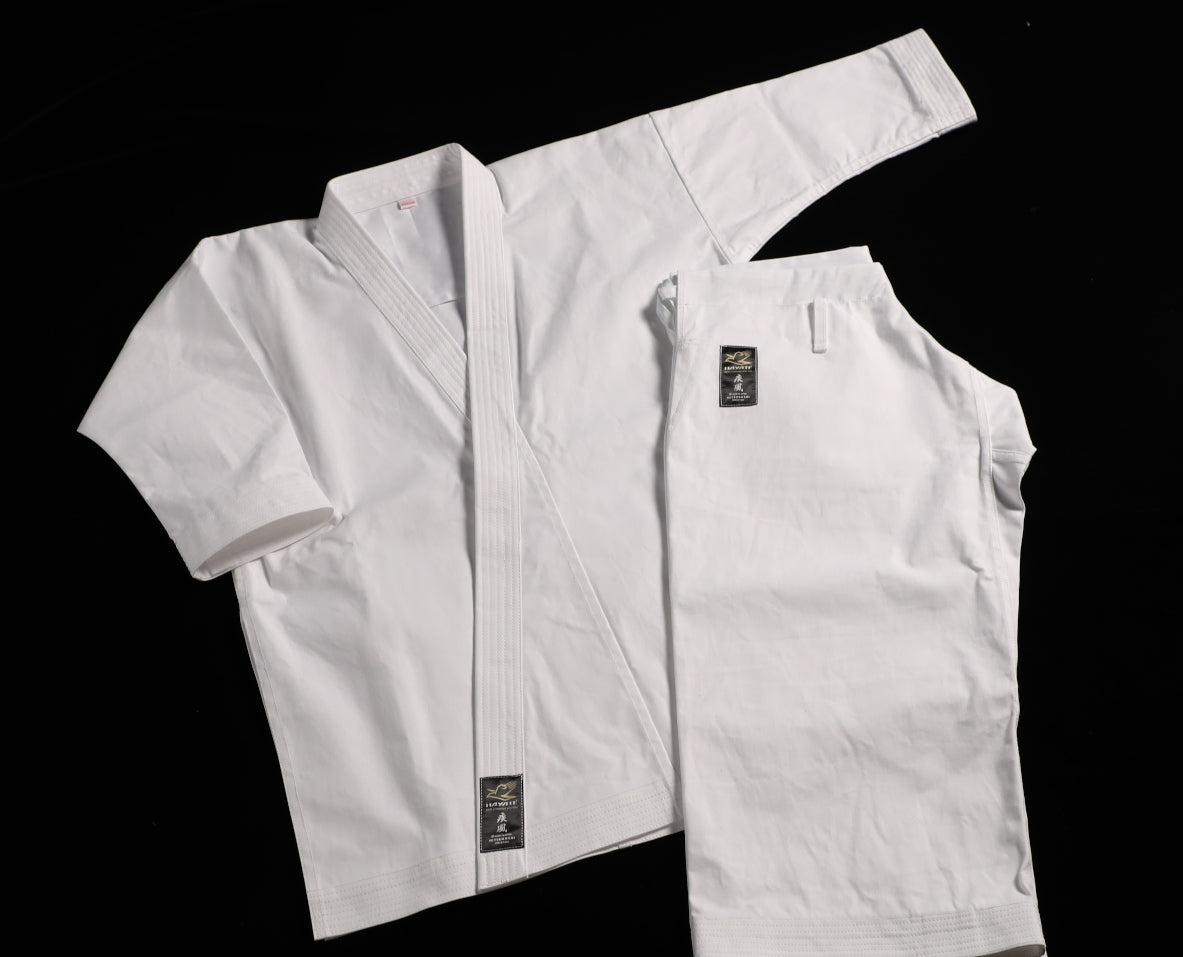 Hayate white martial arts uniform with black patches on a black background