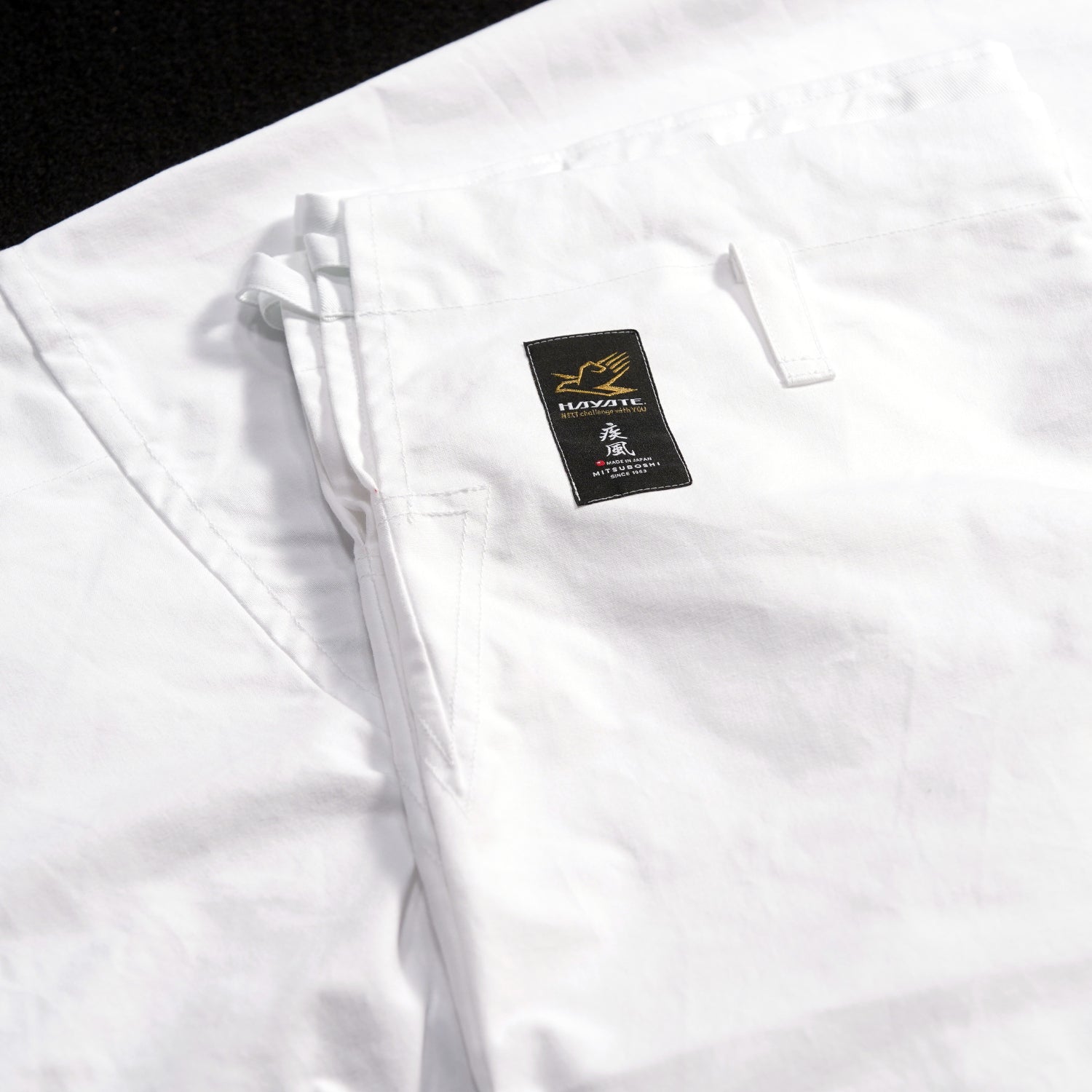 Hayate white martial arts uniform with a visible brand label on a black background
